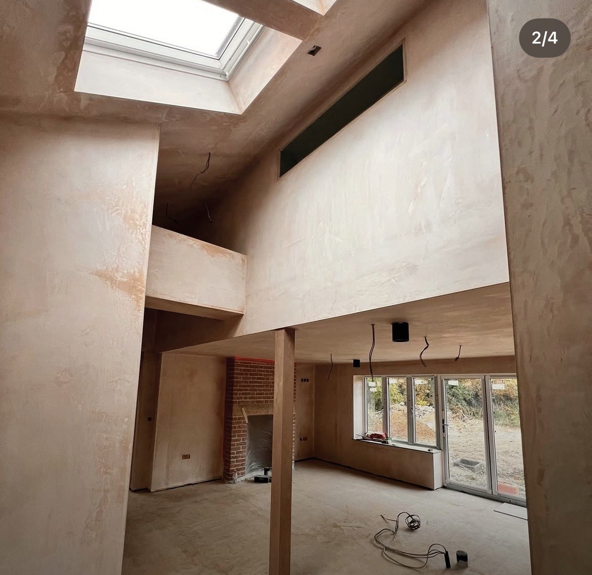 Double-height open plan living space fully plastered by Wall2Wall