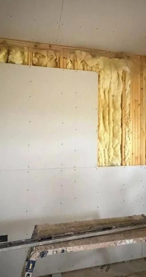 Insulated timber frame wall part-boarded, showing the insulation build-up